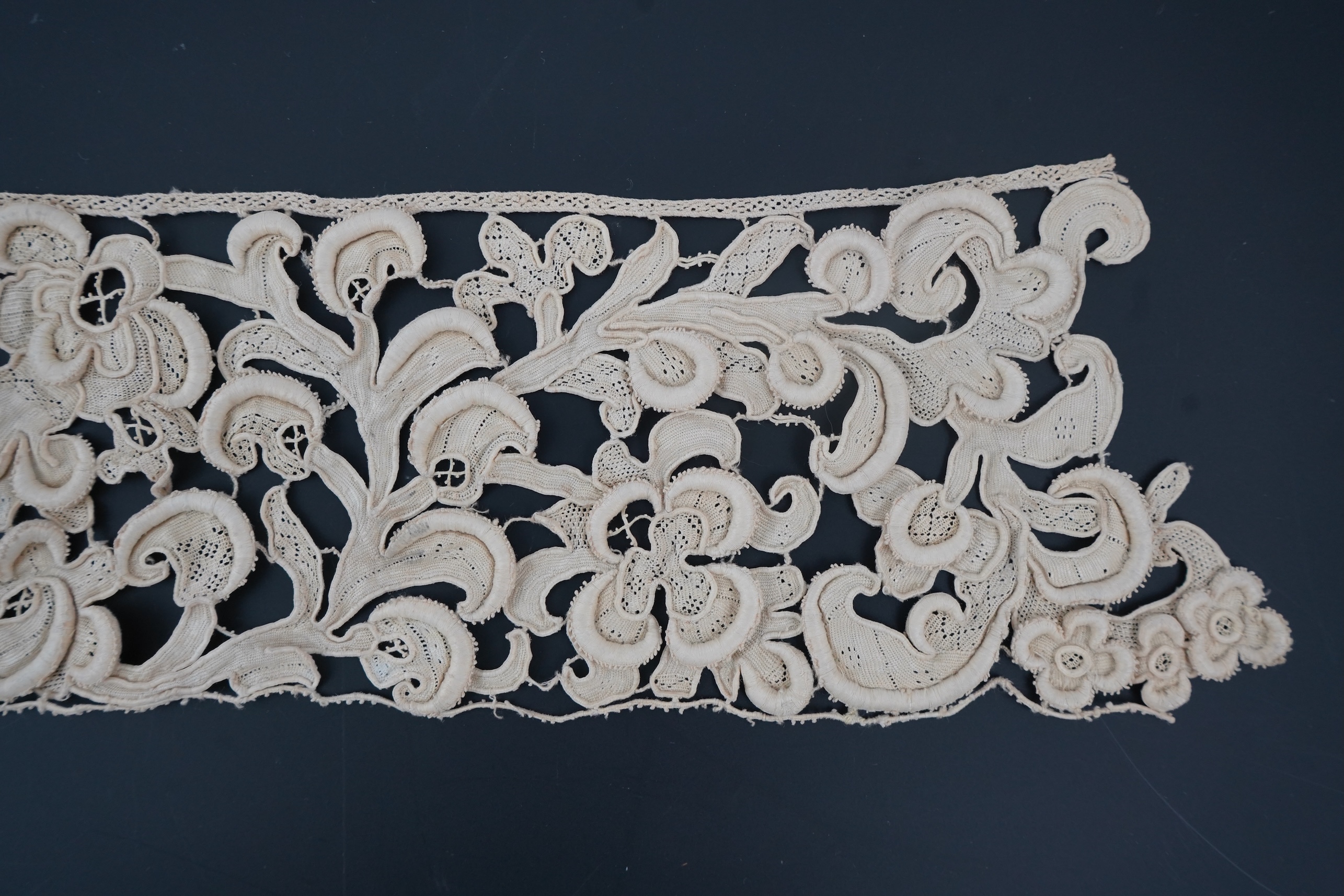 A length of 1660-1670 Italian Venetian Gros Point needle lace, this heavy needle lace was made with a wide cordonnet padded with wool, using close buttonhole stitch, to create large scrolling patterns in heavy relief, li